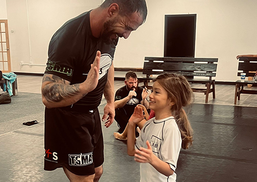 life-changing-goal-setting-img-v2 Jiu Jitsu Coach high fiving a kid